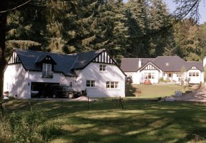 A large white house featuring a prominent slate roof, showcasing its elegant architecture against a clear sky.