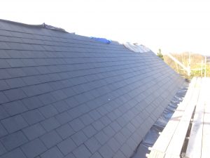 A roof featuring black slate tiles, showcasing a sleek and modern design with a durable finish.