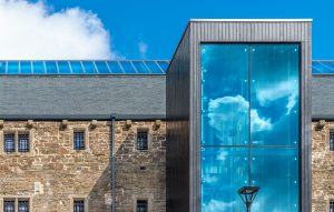 A building with roofing slate installed and a Blue glass on a cladding installed building
