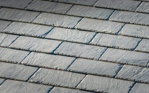 Close-up of a black slate roof showcasing the texture and arrangement of the slate tiles.