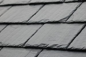 Close-up of a slate roof featuring textured black shingles, showcasing the intricate details and craftsmanship.