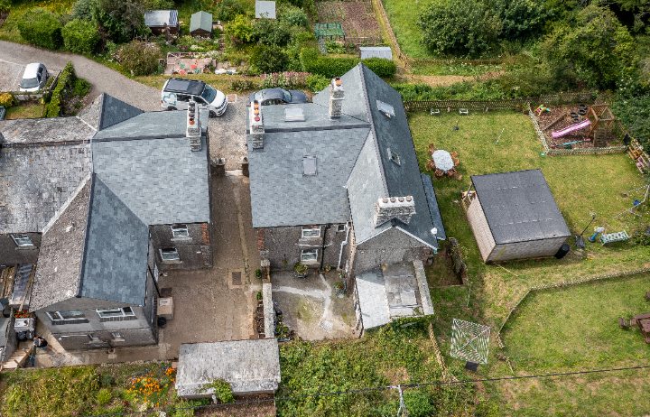 Aerial drone photograph of Coastguard House and Cottages, showing the complex multi-pitched roof layout