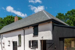 White rendered facade of the Grade II listed Bakers Cottage topped with an authentic Riverstone Ultra Natural Slate roof.